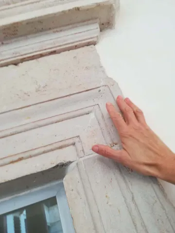 Mano tocca la modanatura a Palazzo Grimaldi, parte dell'esperienza tattile del museo