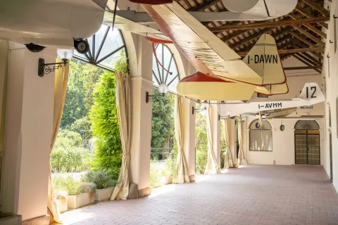 Barchessa delò Castello di San Pelagio che ospita dei grandi modelli di aeroplano del Museo del Volo appesi al soffitto