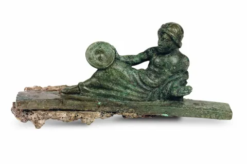 Bronzetto di offerente disteso su kline, V secolo a.C. Bronzo, produzione etrusca, Altezza 5 cm. Proveniente dal santuario di Altino. Parco Archeologico di Altino