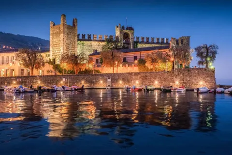 Castello Scaligero di Torri del Benaco che si riflette di notte nell'acqua del Lago di Garda