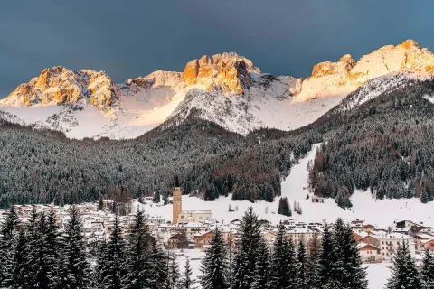 Padola circondata dalle Dolomiti innevate e dai boschi con enrosadira