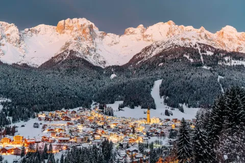 Padola circondata dalle Dolomiti innevate e dai boschi illuminata al crepuscolo