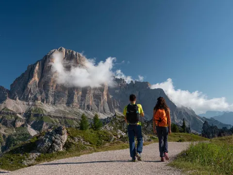 Due escursionisti in 5 Torri con vista sulla Tofana di Rozes in estate