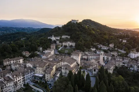 Veduta aerea del borgo di Asolo con la Rocca in cima al colle al tramonto
