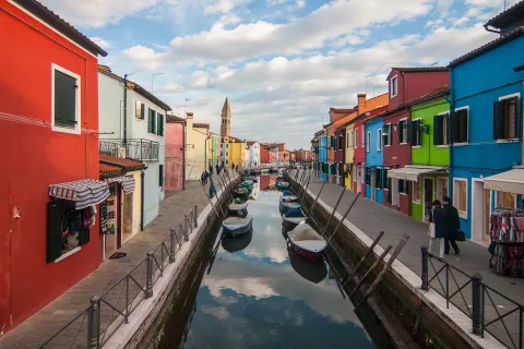 Canale con cielo riflesso e case colorate sull'isola di Burano nella Laguna di Venezia