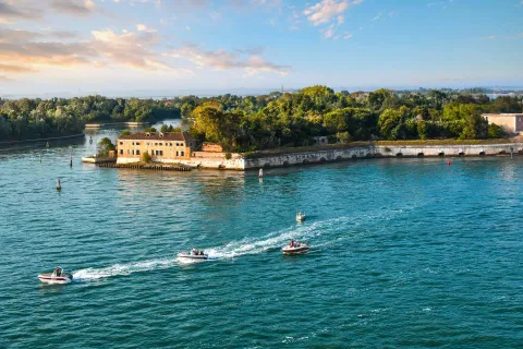 Isola e Forte di Sant'Andrea nella Laguna Veneta con barche in movimento