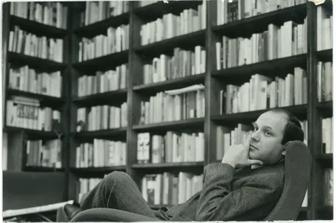 Fotografia in bianco e nero che ritrae Gian Antonio Cibotto circondato dai libri