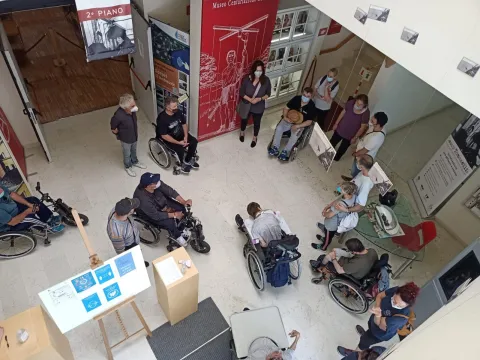 Turisti in sedia a rotelle in una sala del Museo Centuriazione Romana vista di una sala dall'alto