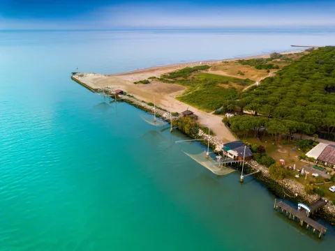 Vista dall'alto del punto in cui il fiume Piave entra nell'Adriatico con alcune bilance da pesca sull'argine