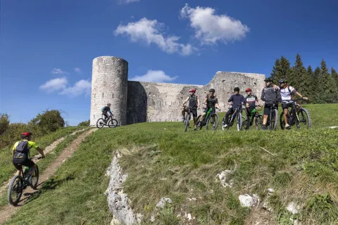 Vari ciclisti all'esterno del Forte Interrotto sull'altopiano di Asiago e dei 7 comuni