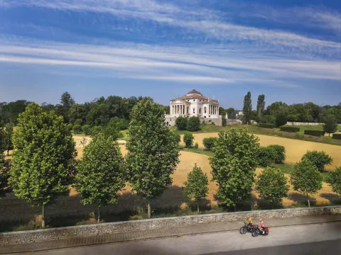 Panoramica con Villa La Rotonda sullo sfondo e due ciclisti sulla strada