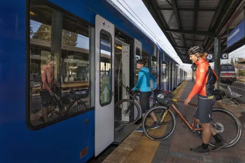 Due ciclisti portano le bici dentro il treno nella stazione di Camposampiero