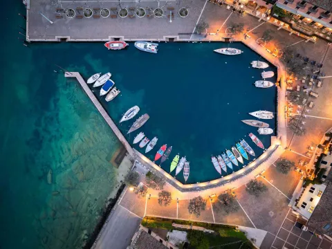 Porticciolo di Torri del Benaco visto dall'alto con barche ormeggiate illuminato al tramonto