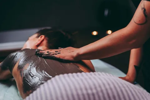 Ragazza si sottopone a un trattamento di fango terapia presso uno degli stabilimenti delle Terme Euganee