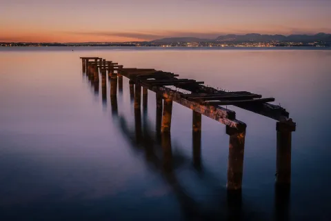Lunga esposizione al crepuscolo del vecchio pontile in rovina al Lido Campanello, Castelnuovo del Garda in provincia di Verona