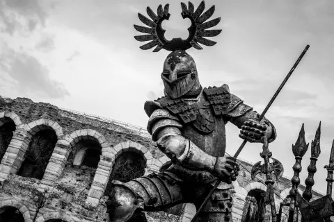 Dettaglio in bianco e nero della scenografia di un'opera lirica e l'Arena di Verona sullo sfondo