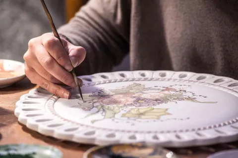 Artigiano che decora una ceramica a Vicenza