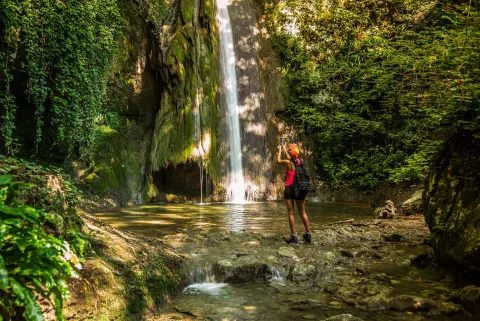 Una persona di fronte a una cascata del Parco delle cascate di Molina