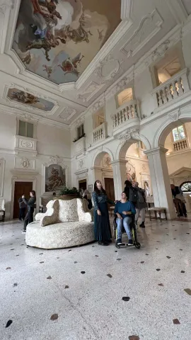 Turista in sedia a rotelle nella sala interna di Villa Zileri, Monteviale