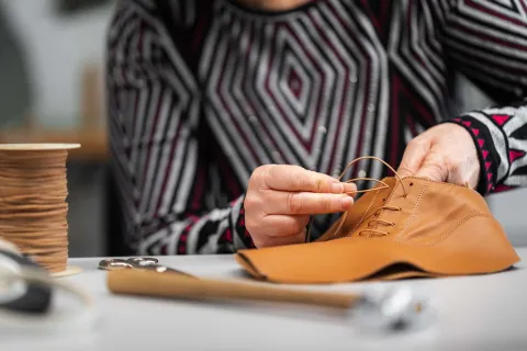 Artigiana cuce una scarpa