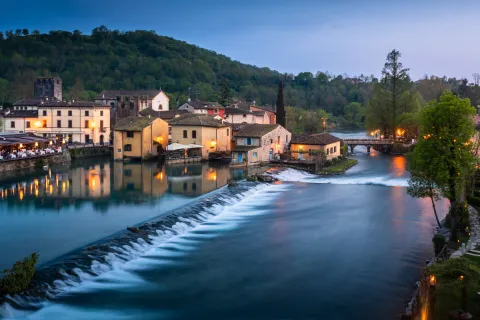 Borghetto sul Mincio illuminato con fiume di sera
