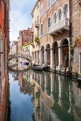 Ponte, canale e portici a Venezia che si riflettono nell'acqua