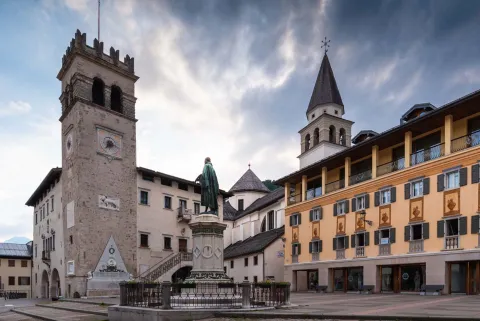 Piazza Tiziano con statua, MARC Museo Archeologico Cadorino "Enrico De Lotto" e campanile del Duomo Arcidiaconale di Santa Maria Nascente a Pieve di Cadore