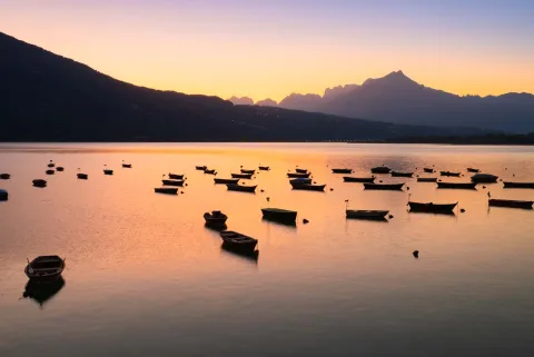 Barche ferme sul Lago di di Santa Croce al tramonto