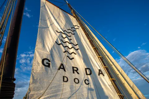 Vela di una barca con il logo del Consorzio di Tutela del vino Garda DOC