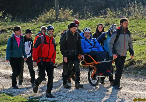 Escursionista trasportato su joëlette in escursione di gruppo