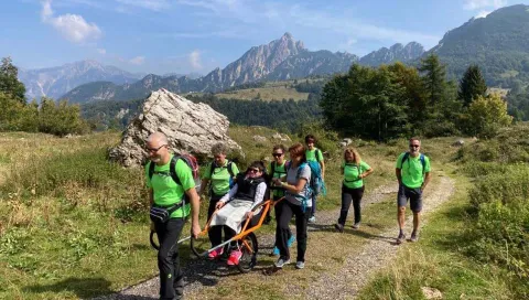 Escursionista trasportato su joëlette in escursione di gruppo