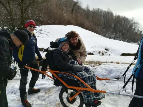 Escursionista trasportata su joëlette in escursione di gruppo