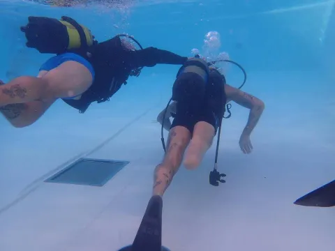 Immersione in piscina con istruttore e amputato