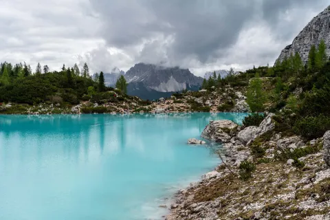 Acque azzurre del Lago di Sorapis nelle Dolomiti Bellunesi in una giornata nuvolosa